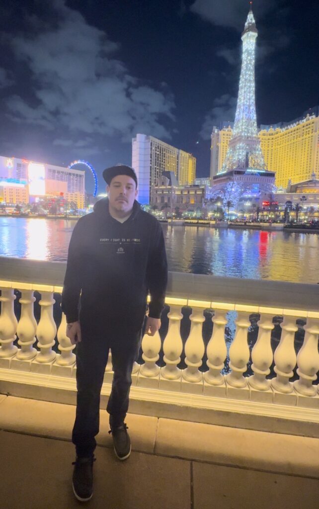 Double Down Mac posing in front of Paris Las Vegas and the Bellagio fountains.