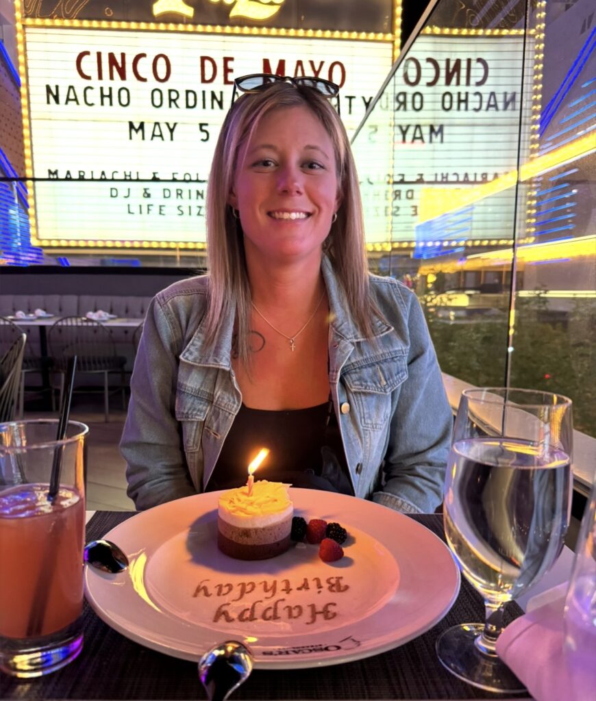 Woman celebrating her birthday with dessert and a drink at a Las Vegas restaurant
