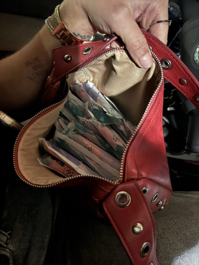 Red purse filled with individually wrapped tampons collected from a casino bathroom.