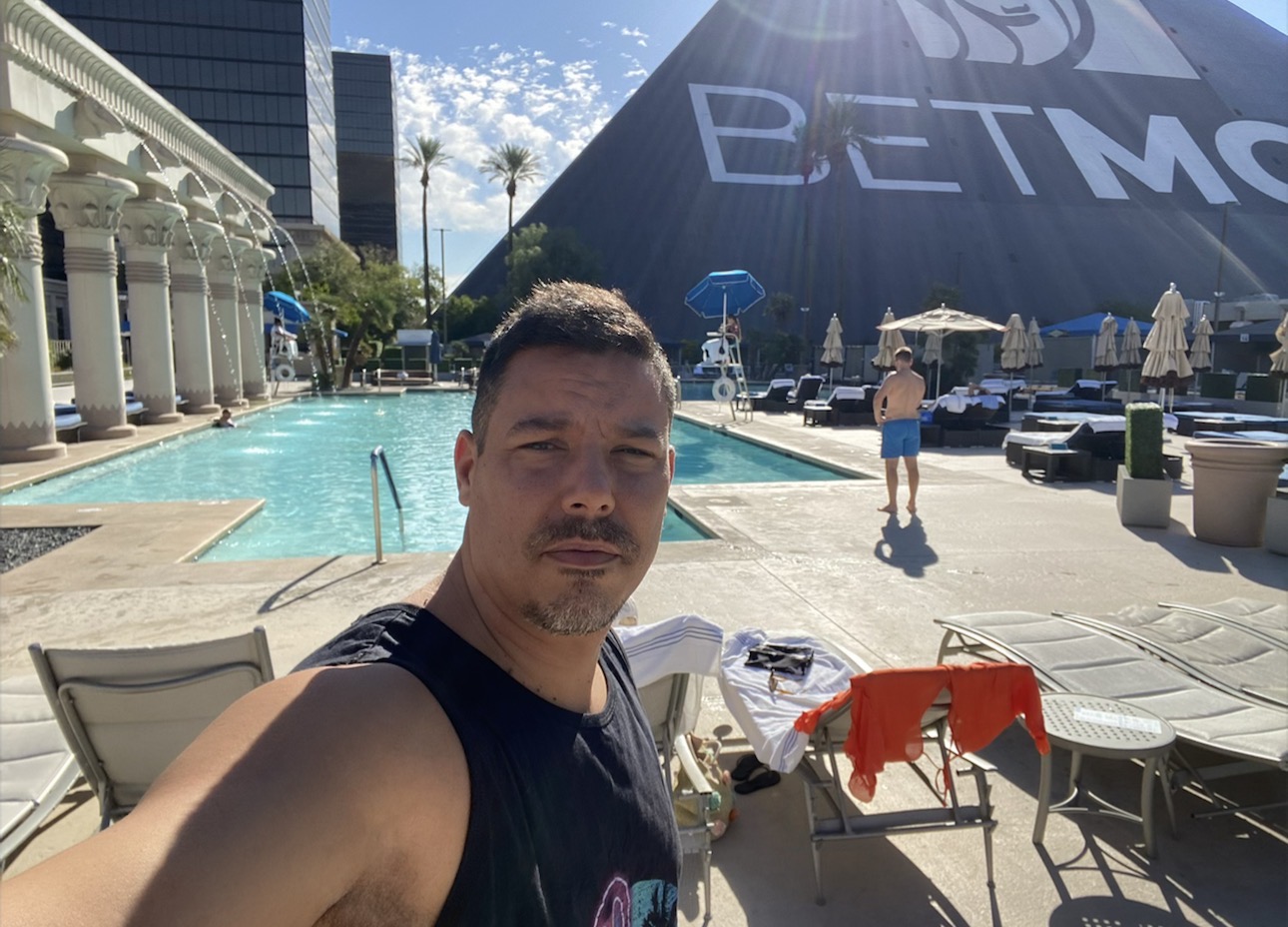 Man standing beside the pool at Luxor Las Vegas with the black pyramid in the background