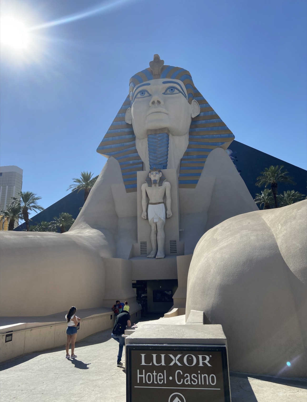 Sphinx statue and entrance outside Luxor Las Vegas under a bright blue sky
